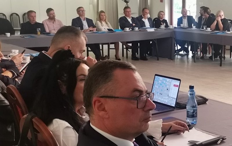 Ludzie przy stołach na konferencji